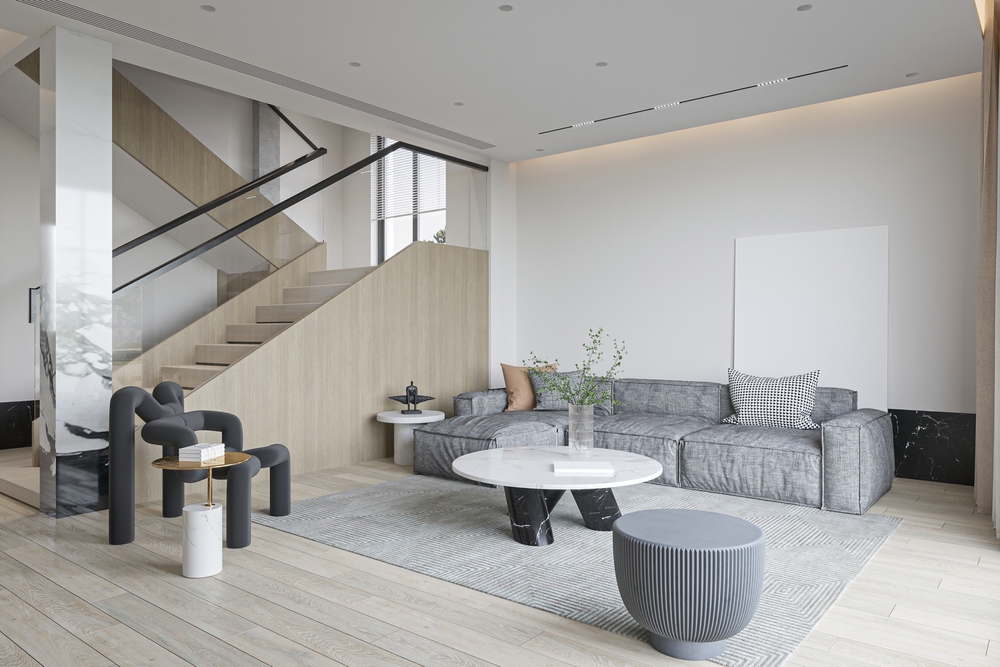 Prostrana dnevna soba sa neutralnim zidovima i velikim tepihom koji povezuje enterijer